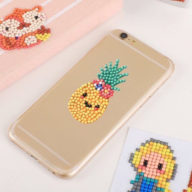 the cellphone has a pineapple diamond painting sticker on it